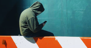 hooded person on cell phone