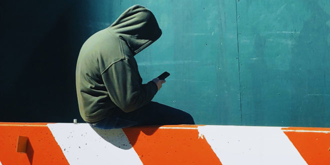 hooded person on cell phone