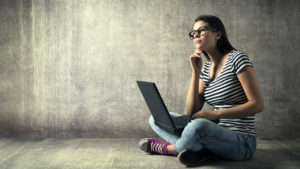 woman at laptop staring into space