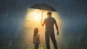 man holding umbrella over himself and little girl