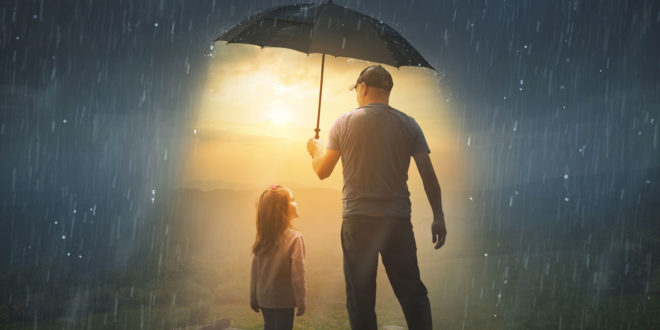 man holding umbrella over himself and little girl