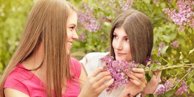two young women looking at flowers