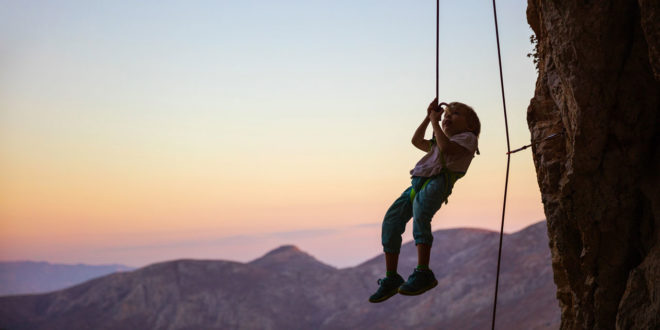 child hanging from rope