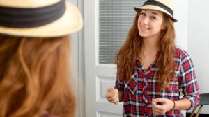 two young women with hats on talking