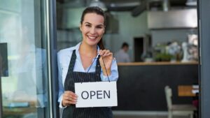 waitress with "open" sign