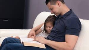 Dad reading to little girl from the Bible
