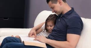 Dad reading to little girl from the Bible