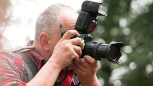 man looking through camera lens