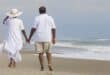 man and woman walking on beach