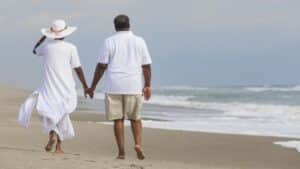 man and woman walking on beach