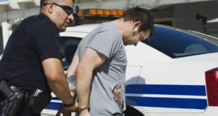 policeman taking handcuffed man away